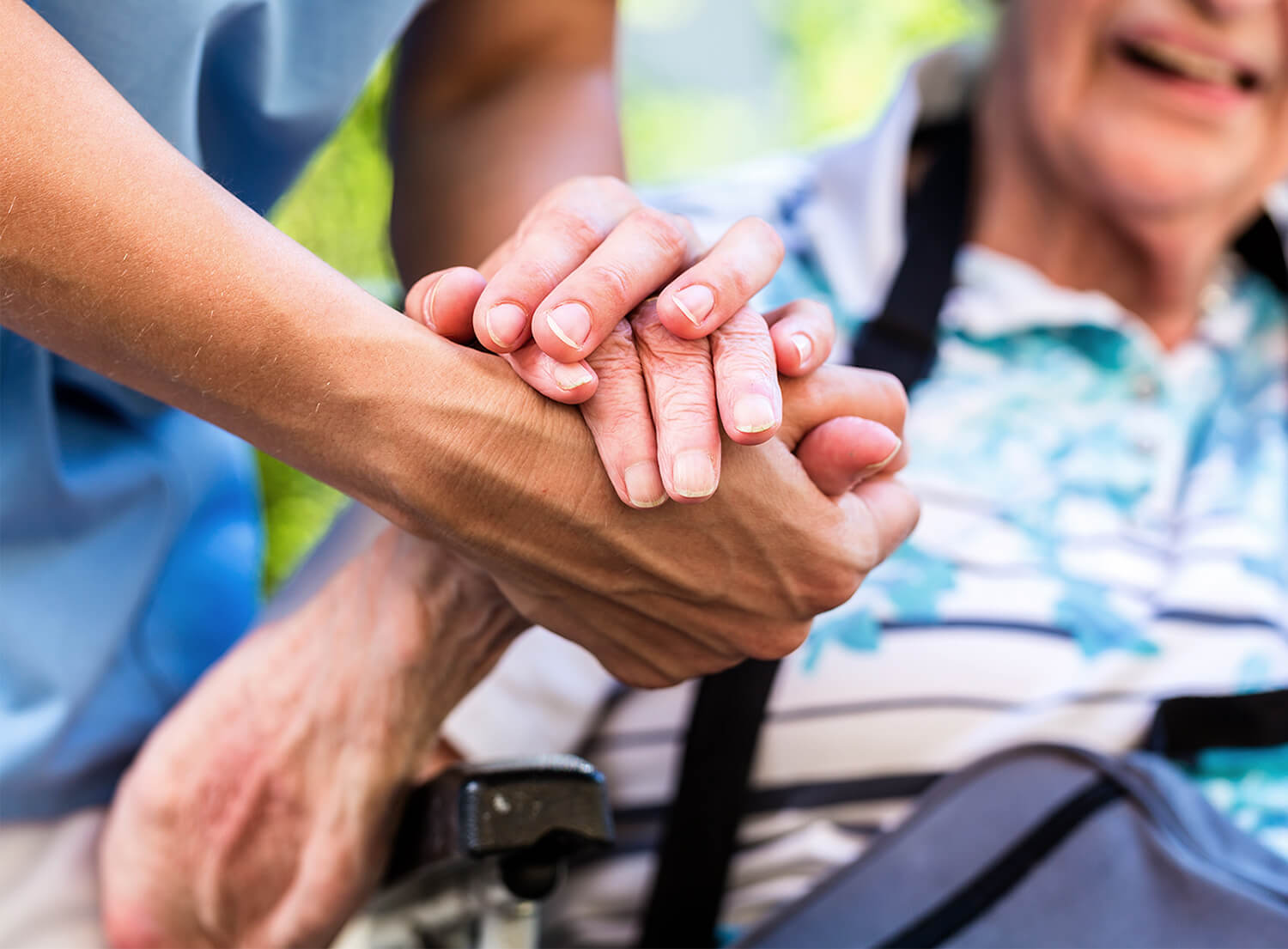 Two hands holding - one a social carer, one a patient
